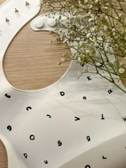 Mushie silikoninen ruokalappu (white letters)